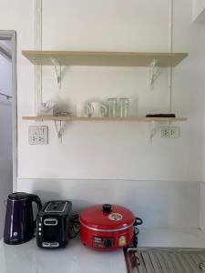 a kitchen with a toaster and a slow cooker on a shelf at Koh Jum Paradise Resort in Ko Jum