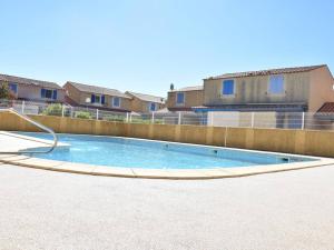 a swimming pool in a yard with a fence at Maison Gruissan, 2 pièces, 6 personnes - FR-1-229-836 in Gruissan