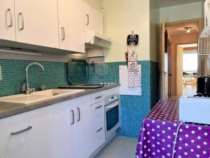 eine Küche mit weißen Schränken, einer Spüle und einer Theke in der Unterkunft Appartement Le Lavandou, 2 pièces, 5 personnes - FR-1-251-443 in Le Lavandou
