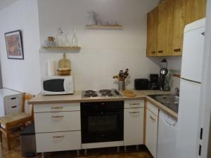 uma pequena cozinha com fogão e micro-ondas em Appartement Hyères, 2 pièces, 4 personnes - FR-1-335-184 em Hyères