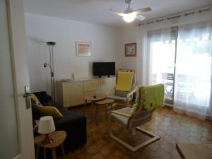 een woonkamer met een bank en stoelen en een televisie bij Appartement Hyères, 2 pièces, 4 personnes - FR-1-335-184 in Hyères
