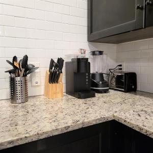 a kitchen counter top with a coffee maker and utensils at Vibrant Vacation Escape with Fast WIFI and KING BED Close to Downtown Houston! in Houston