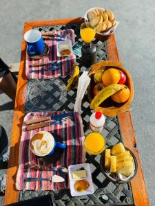 a picnic table with breakfast foods and drinks on it at Hostal Milmahuasi Iruya in Iruya