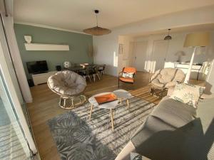 salon z kanapą, krzesłami i stołem w obiekcie Appartement rénové 85m2, terrasse, parking, face à plage - FR-1-494-149 w mieście Royan