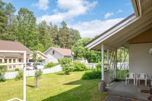 un patio trasero con una valla blanca y una casa en Holiday Home - Detached house 108m2, 3 rooms, 1 living room, Sauna en Joensuu