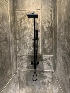 a shower in a room with a wall at Ami Mirissa in Mirissa