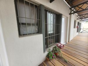 un porche de un edificio con ventanas y macetas en Next door departamento con cochera en Godoy Cruz