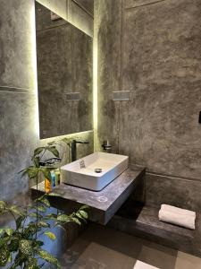 a bathroom with a white sink and a mirror at Ami Mirissa in Mirissa