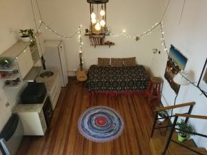 1 dormitorio con cama y alfombra en el suelo de madera en Cute Home en Buenos Aires