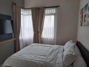 Postel nebo postele na pokoji v ubytování Tabebuya Rumah Liburan Keluarga