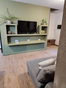sala de estar con TV y sofá en Aires de la Plaza 2 en Salta