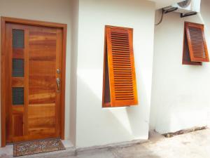 uma porta e janela de madeira numa parede branca em Casa Itabaca II em Puerto Ayora