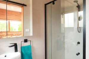 a bathroom with a glass shower and a sink at Escape to a Peaceful Eco Studio in Private Garden in Yapeen