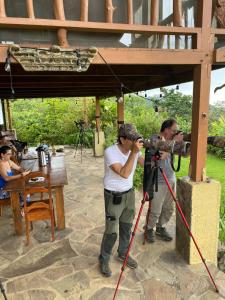 dos hombres tomando una foto delante de una cámara en Birds & Breakfast Costa Rica, en Fortuna