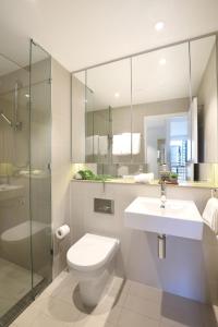 een badkamer met een toilet, een wastafel en een douche bij Orange Stay Apartments in Melbourne