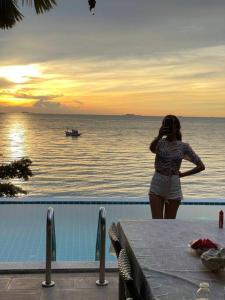 パタヤ・ノースにあるEco stay - Luxury pool + Seaview Villaの海水のスイミングプールの横に立つ女性