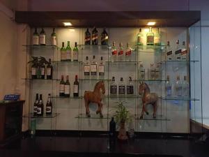 a display case with bottles of wine and a horse statue at Eco stay - Luxury pool + Seaview Villa in North Pattaya