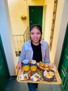 a woman sitting at a table with a tray of food at Hostal Milmahuasi Iruya in Iruya