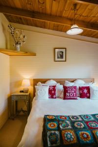 Fleurty's Point Cottage at Franklin South, Huon Valley, Tasmania في Franklin: غرفة نوم بسرير كبير ومخدات حمراء