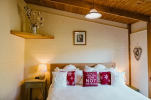 - une chambre avec un lit doté d'oreillers rouges et blancs dans l'établissement Fleurty's Point Cottage at Franklin South, Huon Valley, Tasmania, à Franklin