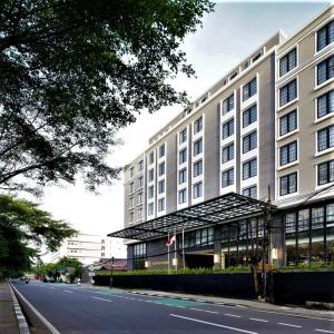 a large building on the side of a street at Maia Hotel Jakarta in Jakarta