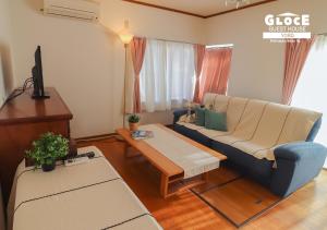 a living room with a couch and a table at GLOCE 養老 西小倉ハウス 1 l 広々とした一軒家を貸切 l 無料駐車場有 l 中長期向け in Yoro