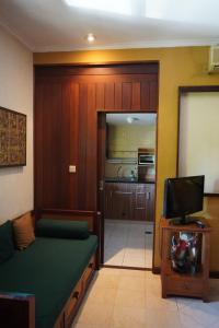 un soggiorno con divano e TV in camera di Pondok Agung Bed & Breakfast a Nusa Dua