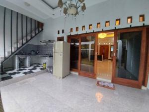 an empty room with a kitchen and a staircase at Tentrem Homestay by FHStay in Sleman