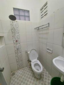 a bathroom with a toilet and a sink at Tentrem Homestay by FHStay in Sleman