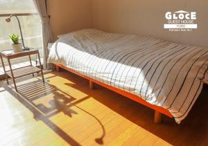 a bed sitting in a room with a glass house sign at GLOCE 養老 西小倉ハウス 2 l 広々とした一軒家を貸切 l 無料駐車場有 l 中長期向け in Yoro