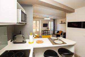 a small kitchen with a counter top and a table at Studi'o Soleil in Cannes