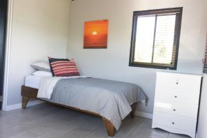 a white bedroom with a bed and a window at Villas Aracari in Alajuela