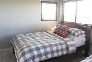 a bed with a checkered blanket and pillows on it at Villas Aracari in Alajuela