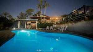 uma piscina azul em frente a uma casa em Villas Aracari em Alajuela