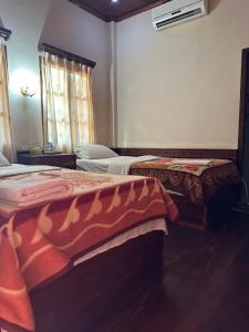 a bedroom with two beds and a window at BKC Villa 2 in Pakbeng