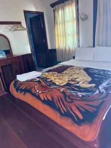 a bed with a blanket with a picture of a lion on it at BKC Villa 2 in Pakbeng