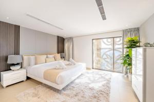 a bedroom with a white bed and a large window at Ultra Luxury JBR Duplex Penthouse - Beach Resorts Neighbourhood in Dubai +155 photos