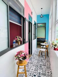 a hallway with a table and chairs and flowers at Little Quy Nhơn Homestay in Quy Nhon
