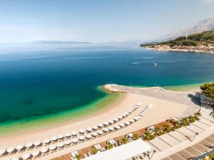 an aerial view of a beach with umbrellas and the ocean at Apartments Maja 100 from the beach in Podgora