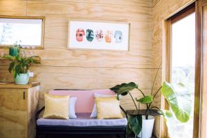 a pink bench in a room with wooden walls at Escape to a Peaceful Eco Studio in Private Garden in Yapeen