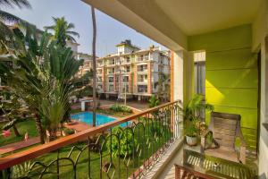 - un balcon avec une piscine et un bâtiment dans l'établissement Amazing Pool View Candolim Goa 2BHK Apartment, à Candolim