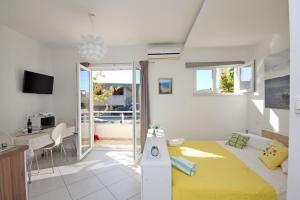 a bedroom with a bed and a desk and a kitchen at Apartments Maja 100 from the beach in Podgora