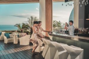 a group of people sitting at a bar at a resort at Crowne Plaza Sanya Haitang Bay Resort, an IHG Hotel in Sanya