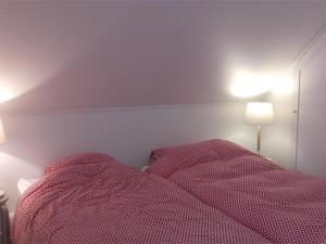 プルームール・ボドゥーにあるMaison Pleumeur-Bodou, 3 pièces, 4 personnes - FR-1-368-14のベッドルーム1室(ピンクのシーツとランプ2つ付)