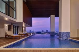 a pool in a building with a view of the city at BIJOU Serviced Residence in Phnom Penh