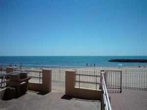 uma vista para uma praia com um banco e para o oceano em Studio Le Grau d'Agde, 1 pièce, 4 personnes - FR-1-423-26 em Le Grau-dʼAgde