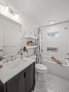 a bathroom with a sink and a toilet and a tub at Modern Home With A Finished Entertainment Basement in Royal Oak