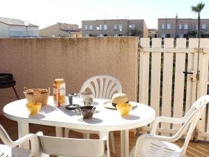 a white table and chairs on a patio at Maison 2 Pièces Mezzanine Proche Plage, Animaux Acceptés, Parking - FR-1-229D-55 in Fleury