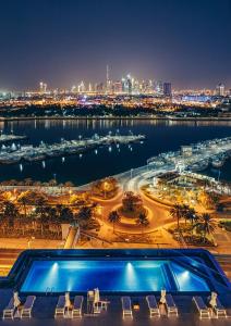 a swimming pool with a view of a city at night at Al Bandar Arjaan by Rotana – Dubai Creek in Dubai