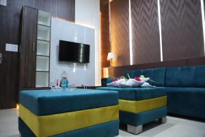 un soggiorno con divani blu e TV di SRG INN HOTEL a Bharatpur